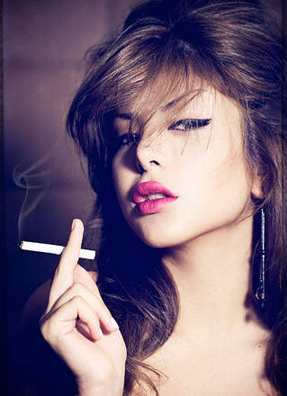 Primer plano de una mujer fumando un cigarrillo.