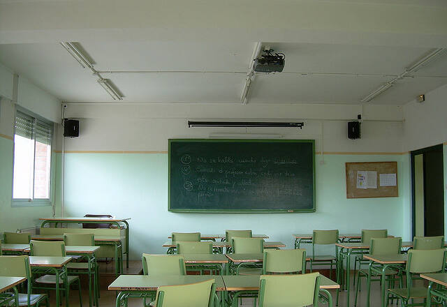 Foto de la pizarra de un aula desde la zona de pupitres