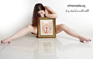 Mujer abierta de piernas tapándose con un cuadro que representa el interior del órgano reproductor femenino