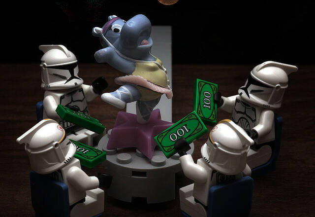Soldados imperiales de lego en una mesa dando dinero a una hipopótoma morada que baila sobre ella
