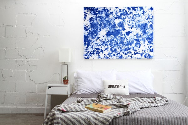 Lienzo azul pintado con love is art kit como cabecero de una habitación