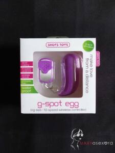 Caja del g-spot egg en el que se ve el huevo morado con forma de "J" y el mando con tapa del mismo color