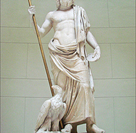 Estatua de Zeus en mármol blanco. De pie, con un cetro en su mano derecha y un águila junto a su pie derecho.