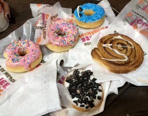 Foto de los donuts de la merienda: dos rosas, uno azul, otro blanco y pepitas negras y una caracola.