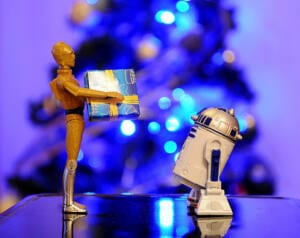 Muñeco C3PO dándole un paquete envuelto a R2D2