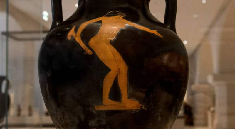 Representación en vasija de una mujer con un olisbo en la mano