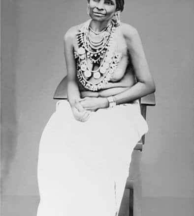 Fotografía en blanco y negro de una mujer de Kerala con el torso desnudo tapado por collares