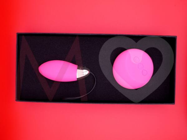 Huevo vibrador rosa LYLA 2 junto con su mando a distancia dentro de su caja de presentación negra.