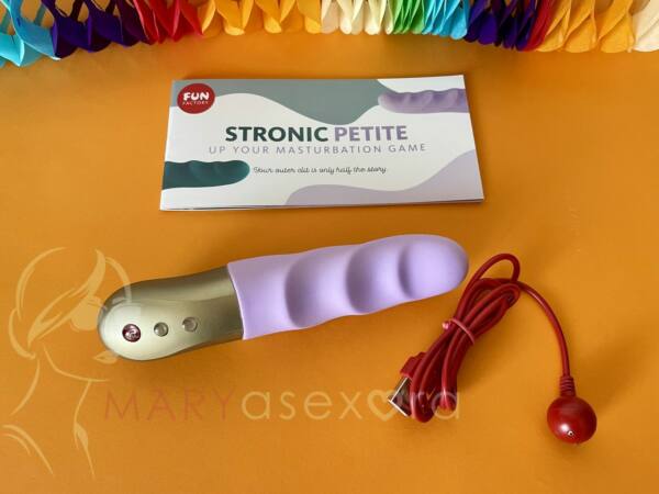 Contenido Stronic Petite: pulsador color lila, cable cargador USB rojo y libreto información