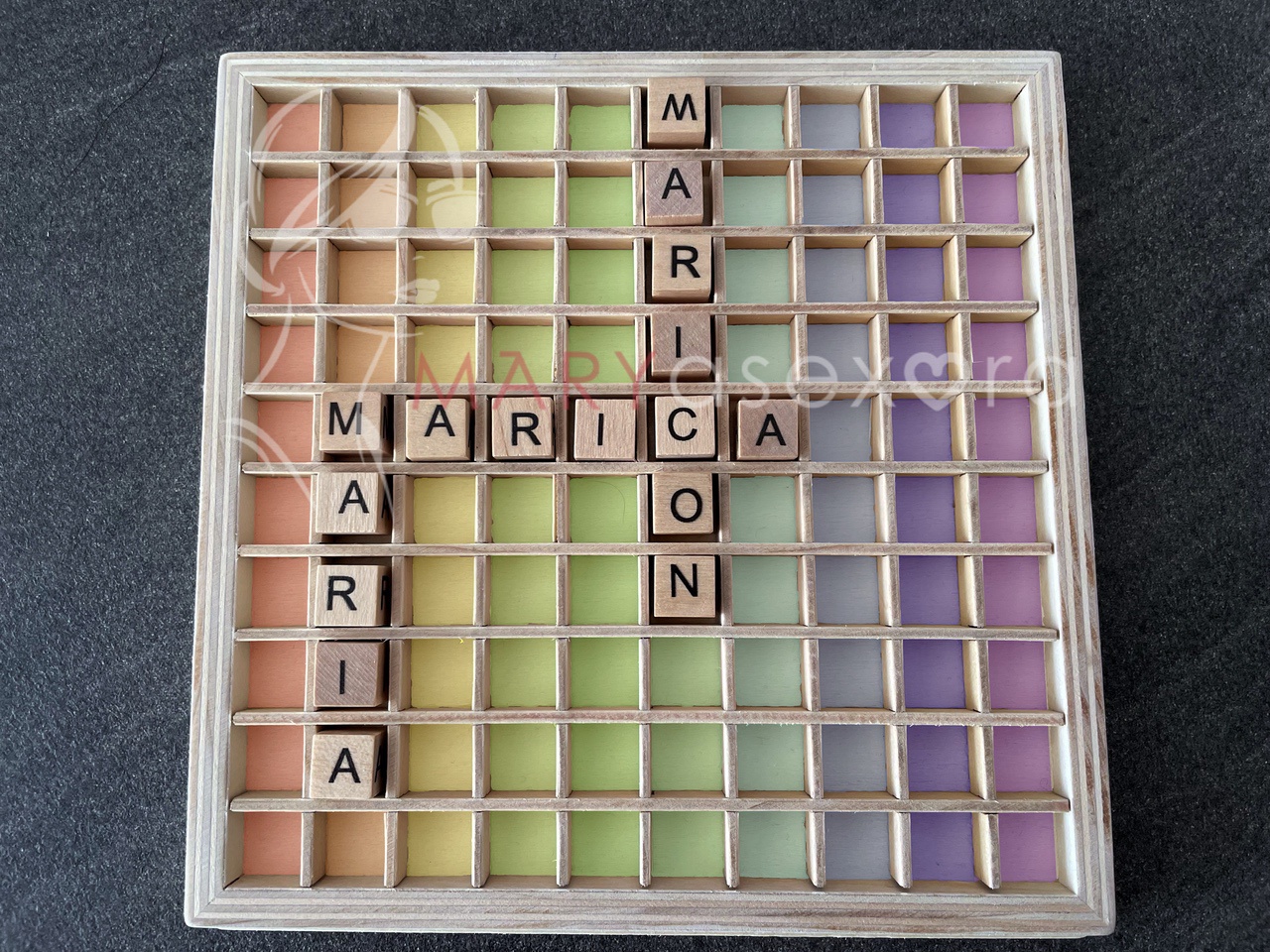 Scrabble de madera con los colores del arco iris y las palabras: maría, marica, maricón.